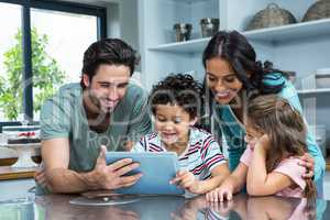 Happy family using tablet in kitchen