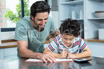 Kind father helping his son doing homework