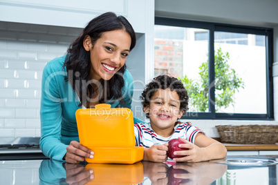 Smiling mother and son going to eat an apple