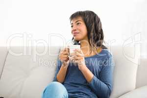Smiling casual woman holding coffee and looking otherwise
