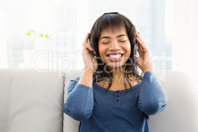 Casual smiling woman listening music with headphones