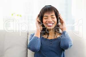 Casual smiling woman listening music with headphones