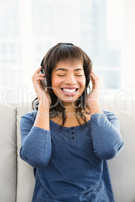 Casual smiling woman listening music with headphones