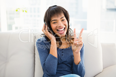 Casual smiling woman listening music with headphones