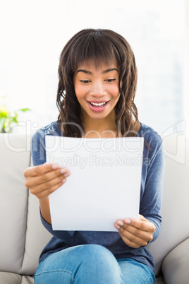 Casual smiling woman reading paper