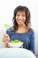 Casual smiling woman eating salad