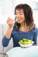 Casual smiling woman eating salad