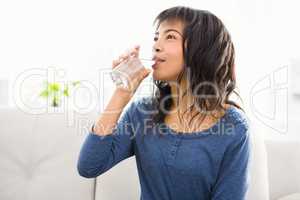 Casual smiling woman drinking some water