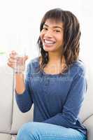 Casual smiling woman holding a glass of water