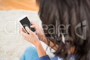 Over shoulder view of casual woman using her smartphone