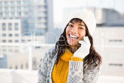 Smiling woman wearing winter clothes and having a phone call