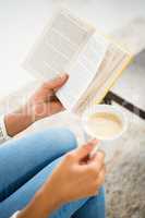 Close up view of woman holding cup of coffee and book