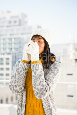 Smiling woman wearing winter clothes and drinking coffee