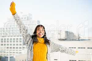 Smiling woman wearing winter clothes with outstretched arms