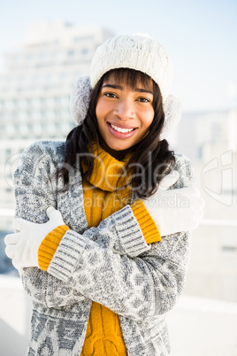 Smiling woman wearing winter clothes with arms crossed