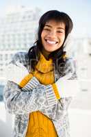 Smiling woman wearing winter clothes with arms crossed