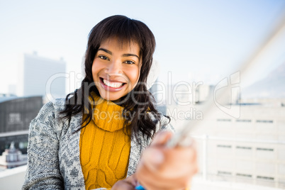 Smiling woman wearing winter clothes and taking a selfie