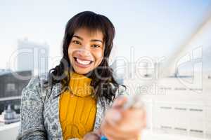 Smiling woman wearing winter clothes and taking a selfie