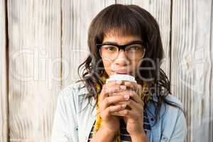 Smiling casual woman posing with glasses while drinking coffee