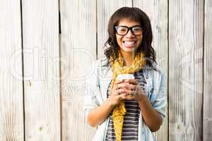 Smiling casual woman posing with glasses while holding coffee