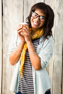 Smiling casual woman posing with glasses while holding coffee