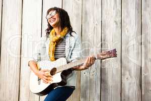 Smiling casual woman playing guitar