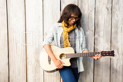 Smiling casual woman playing guitar