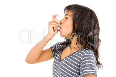 Casual woman using her inhaler