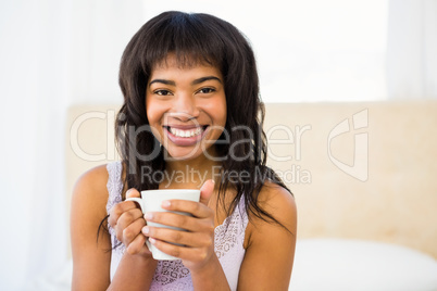 Casual smiling woman holding a cup of coffee