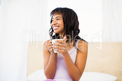 Casual smiling woman holding a cup of coffee