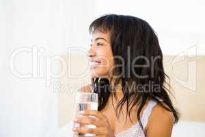 Casual smiling woman holding a glass of water