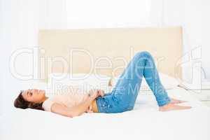 Casual smiling woman trying to close her jeans