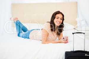 Casual smiling woman lying on bed