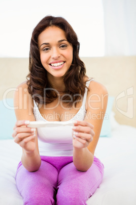 Happy woman looking at her pregnancy test