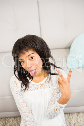 Casual smiling woman gesturing peace sign