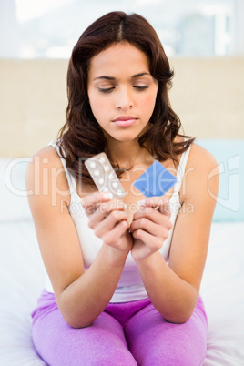 Concerned woman looking at contraception