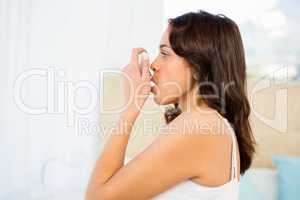 Side view of a woman using her inhaler