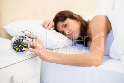 Sleeping woman stopping her alarm