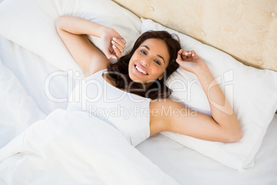 Pretty woman waking up with outstretched arms