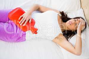 Woman lying on her bed with a belly pain