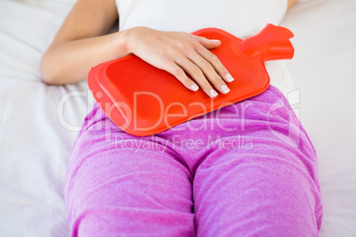 Woman lying on her bed with a belly pain