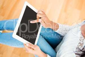 Woman using digital tablet on floor