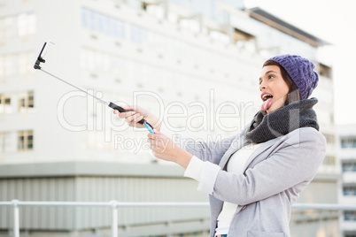 Happy woman using selfie stick