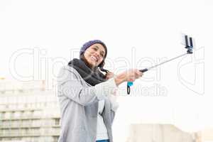 Happy woman using selfie stick