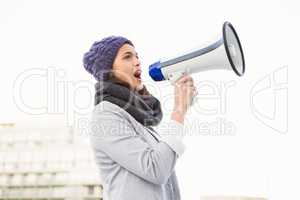 Serious woman shouting with megaphone