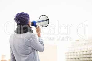 Rear view of woman shouting with megaphone