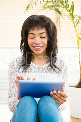 Smiling woman using digital tablet