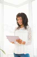Smiling woman using her tablet in living room