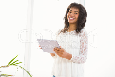 Smiling woman using her tablet in living room