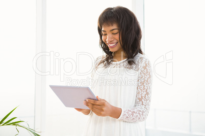 Smiling woman using her tablet in living room